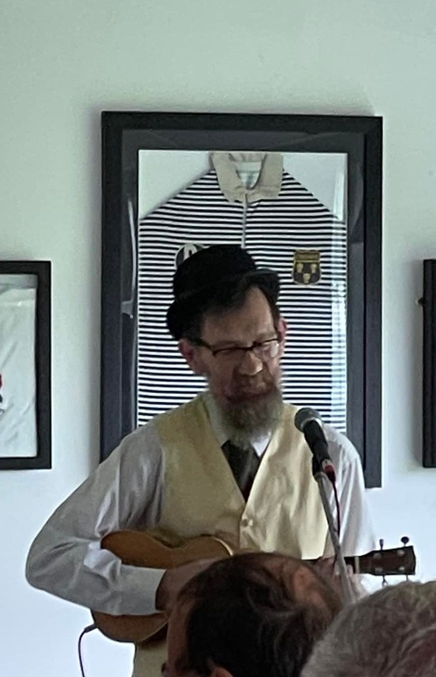 Eric in (18) 80s costume playing a tenor uke.