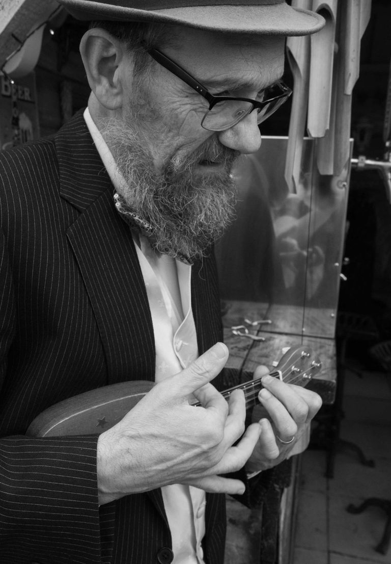 black-and-white side-on photo of Eric playing mini uke.